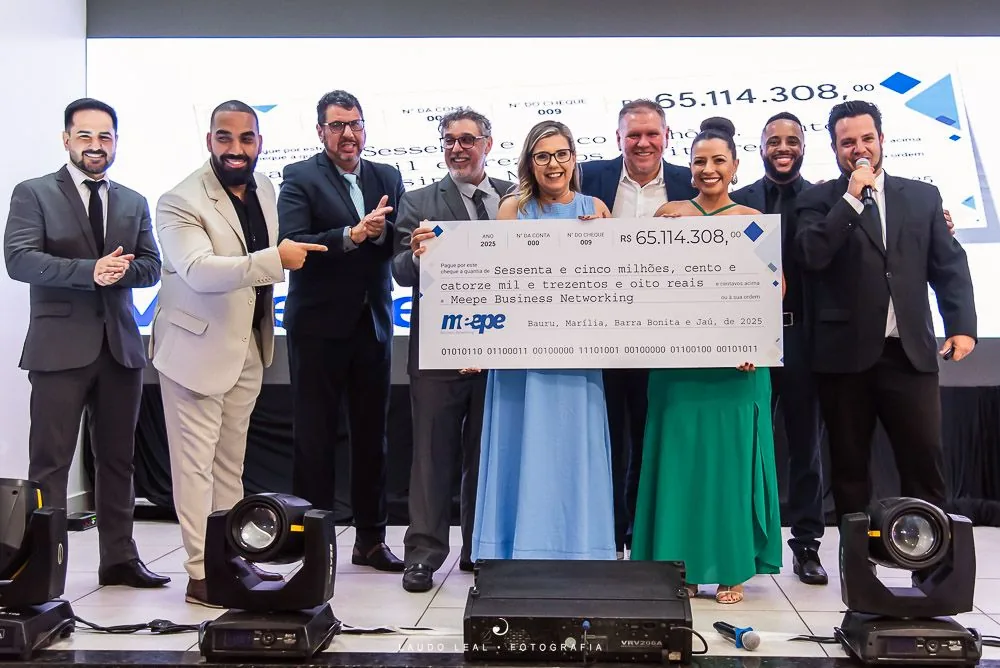 Empresários posando com um cheque simbólico na Convenção Meepe 2025